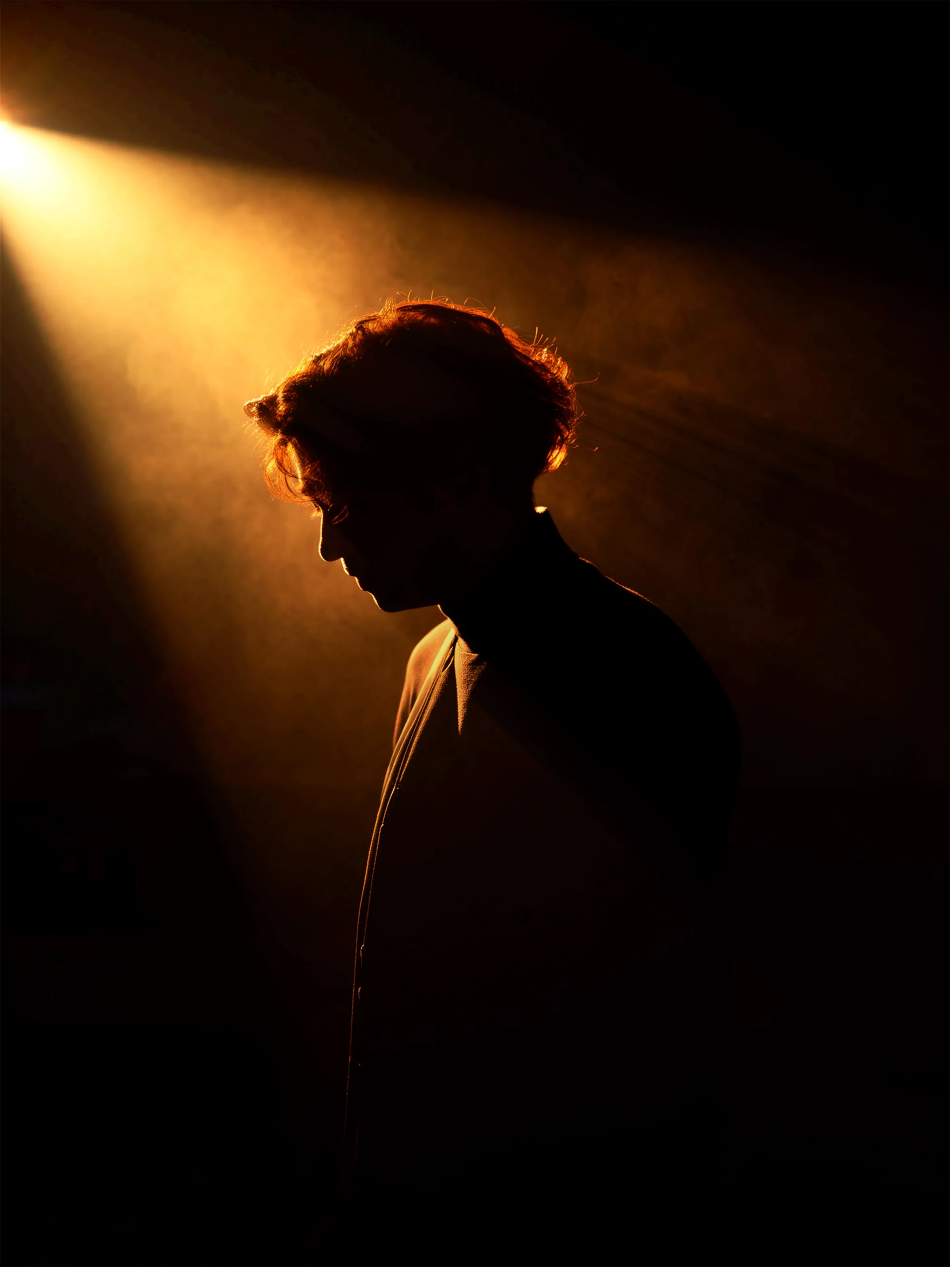 Side-profile portrait of Sami Fathi in warm stage light